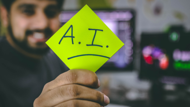 A man holding up a piece of paper with the words A.I written on it