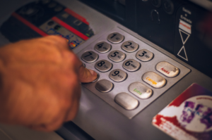 Finger typing out pin at atm