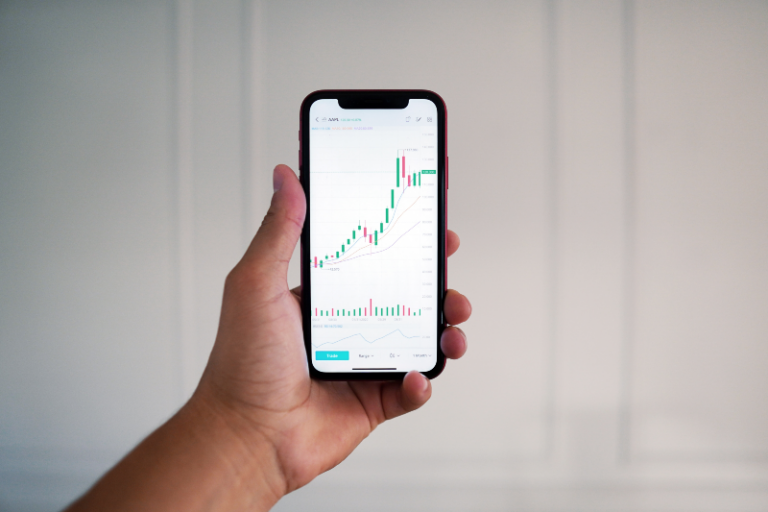 A picture of a phone with a trading platform for investing.